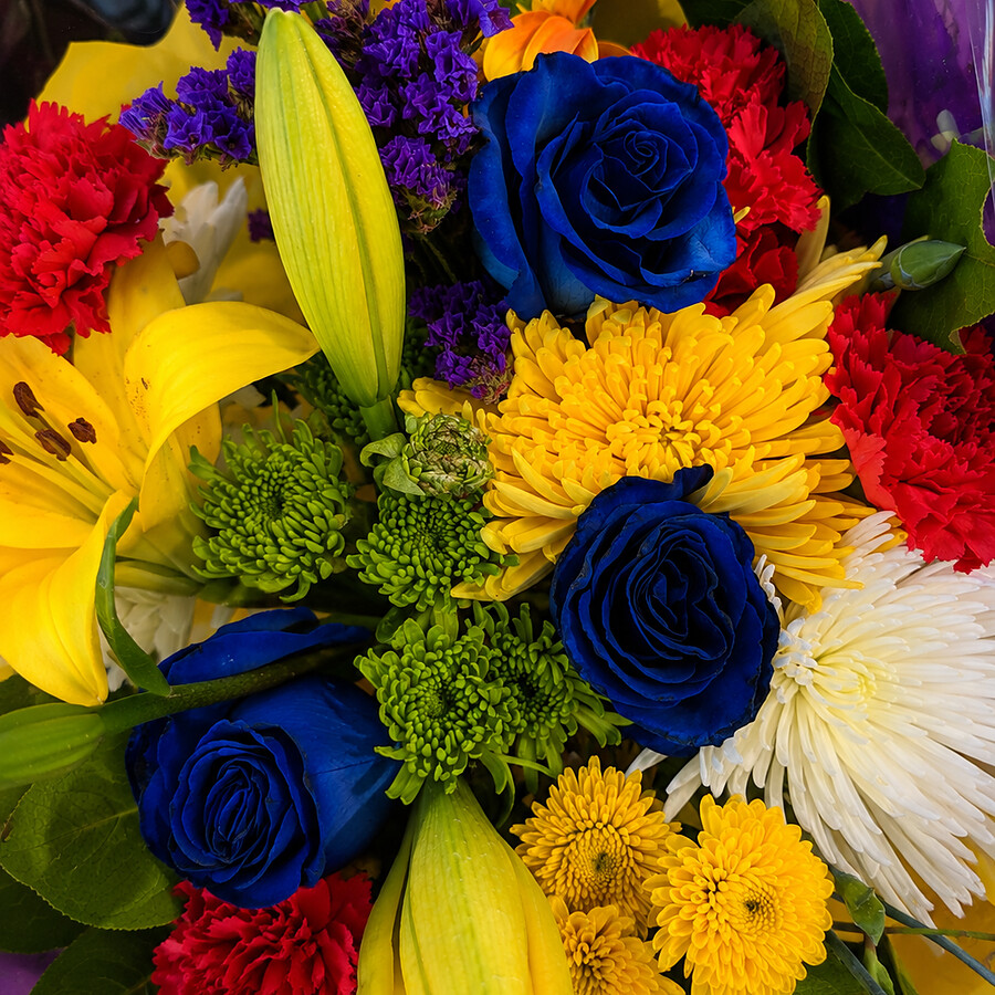 Vivid bouquet with blue roses, yellow lilies and red carnations