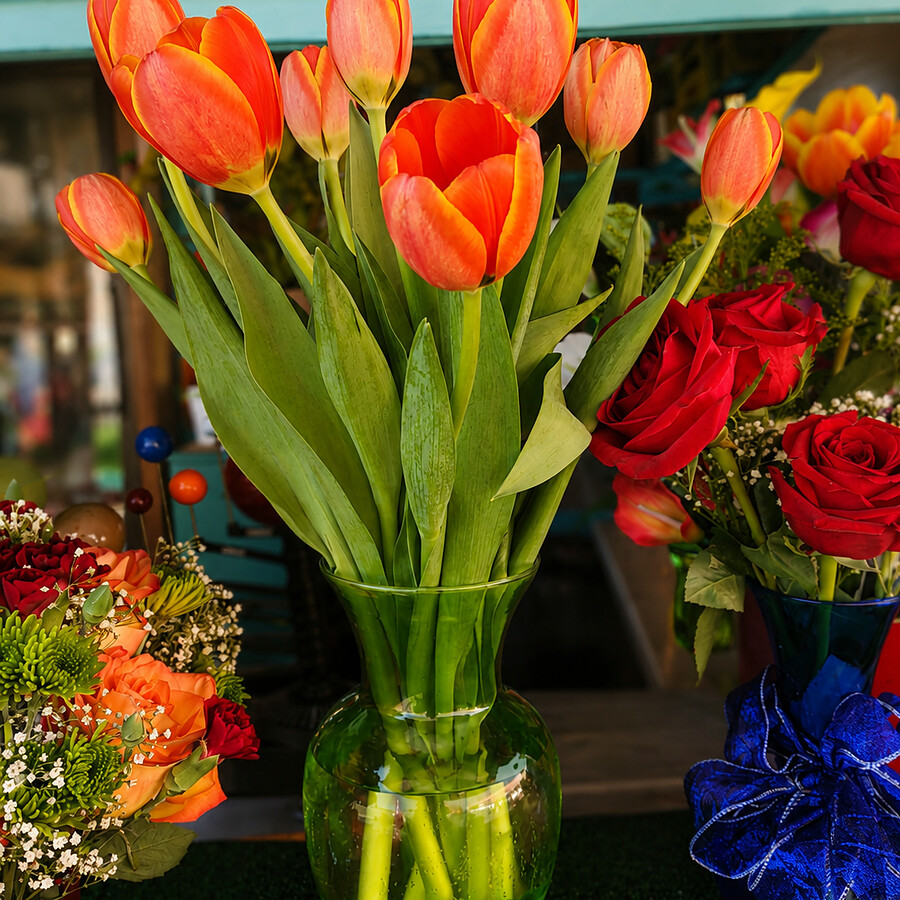 Orange tulips in a clear vase at the teal Blossoms storefront