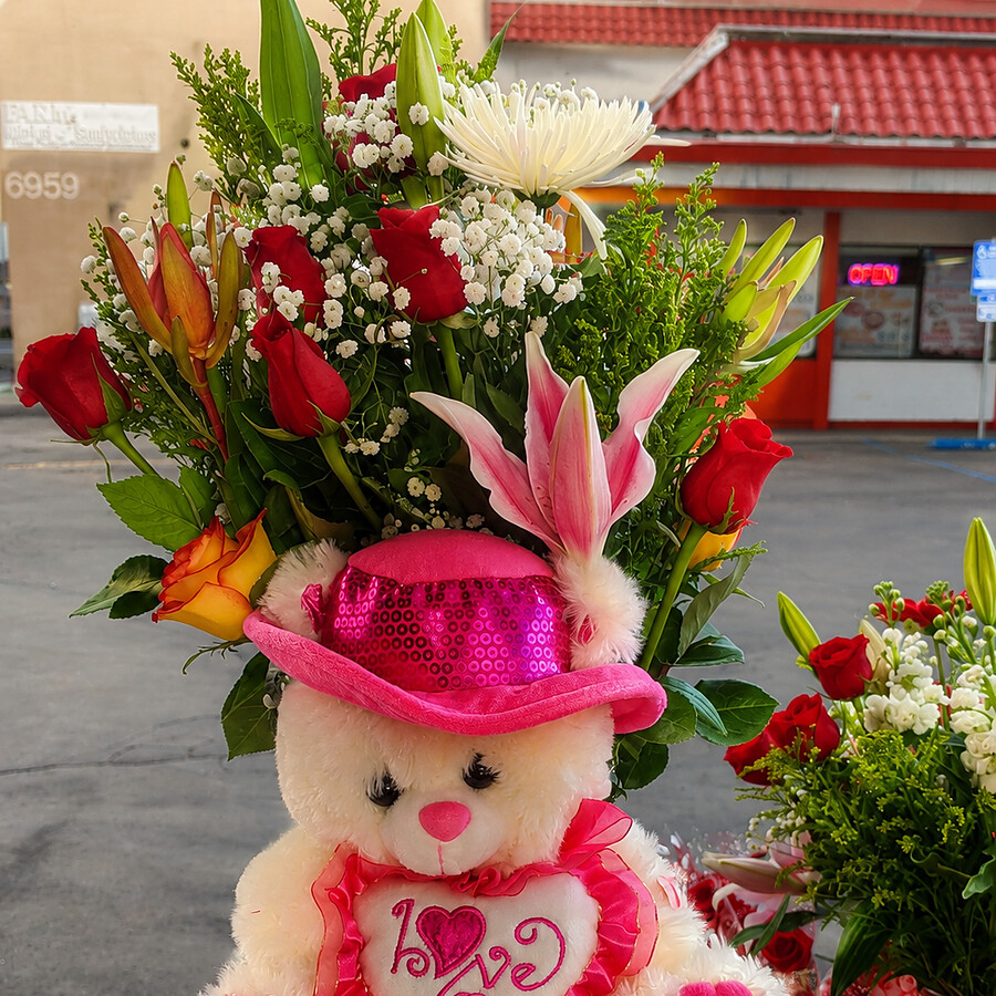 Red rose arrangement with a plush love bear gift