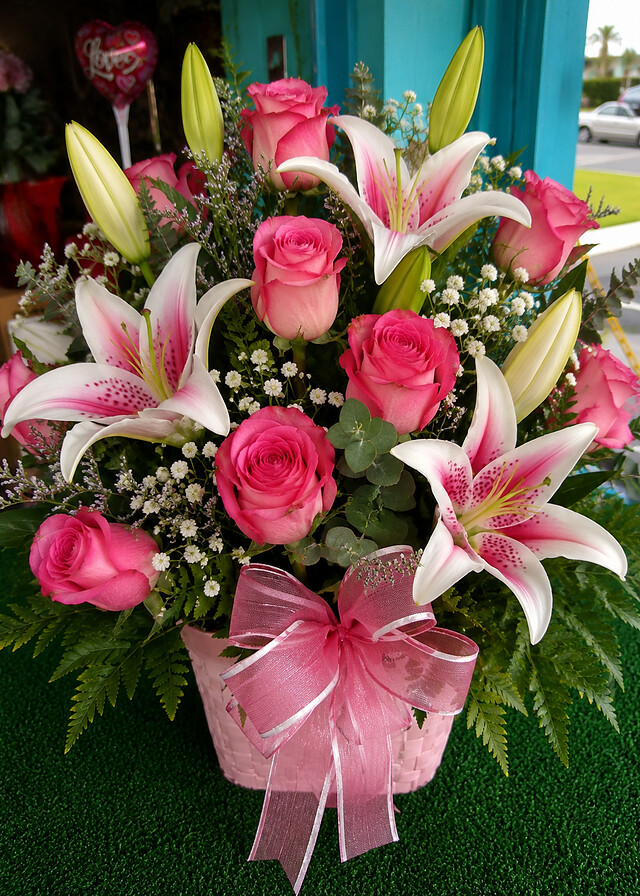 Pink roses and stargazer lilies in a basket from Blossoms Flower Shop